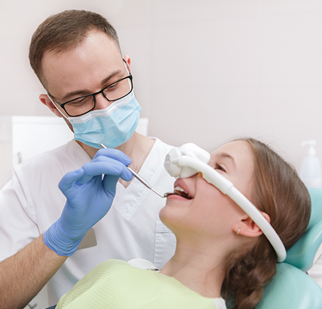 A woman at the dentist with a mask getting sedation